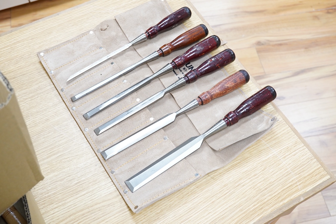 Five woodworking chisel sets, all in leather rolls, including an unused nine piece set by Robert Sorby, a six piece set by Henry Taylor, and three other sets showing some wear